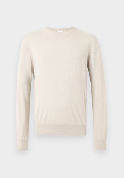 Μπεζ πουλόβερ με μακριά μανίκια και στρογγυλή λαιμόκοψη, με ριμπ μανσέτες και στρίφωμα, εμφανίζεται πάνω σε απλό φωτεινό φόντο.