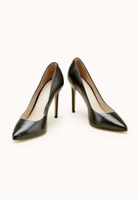 Escarpins en cuir noir avec bout pointu, talons aiguilles fins, finition lisse et design minimaliste.
