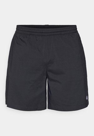 Pantalones cortos negros de tela ligera, con cinturilla elástica, corte relajado y un pequeño acento de logo en el dobladillo.
