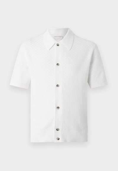 Λευκό πλεκτό πουκάμισο με κοντό μανίκι και γιακά, με έξι μπροστινά κουμπιά και διακριτό υφασμάτινο σχέδιο.