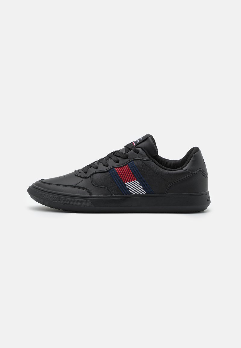 Sneakers neri in pelle con una texture liscia. Presentano un motivo a strisce diagonali colorate in rosso, bianco e blu sul lato.