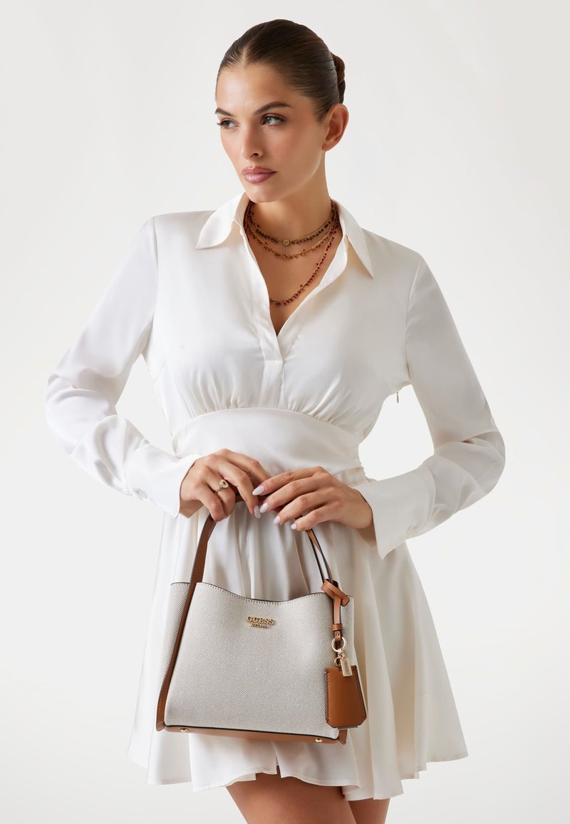 Light gray textured handbag with brown leather accents. Features a dual-tone design and a small charm attached to the handle.