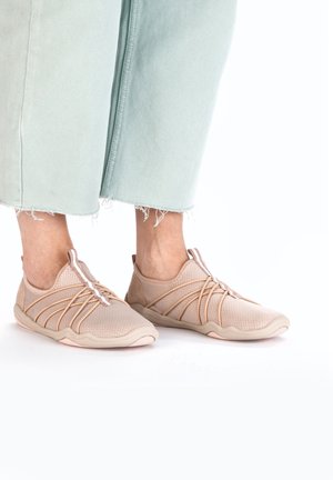 Beige Sportchuhe mit einem Mesh-Obermaterial, elastischem Schnürsystem und einer flexiblen Sohle. Mit dezenten Akzenten und strukturierten Mustern.