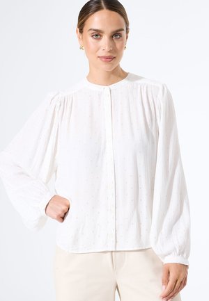 Witte lange mouw shirt met een knoopsluiting aan de voorkant, geplooide textuur en subtiele gouden stipaccenten door het hele shirt. Ronde halslijn en een relaxte pasvorm.