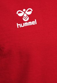 Rode katoenen T-shirt met een wit Hummel-logo met gestileerd bijontwerp, korte mouwen en een ronde halslijn. Soepele textuur.