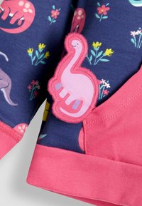 Tengerészkék póló színes dinoszaurusz és virágmintával, rózsaszín dinoszaurusz applikációval és rózsaszín bordázott aljjal. Puha pamut anyag.