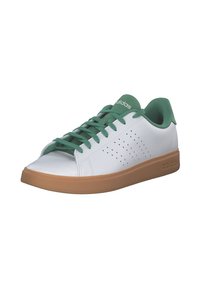 Zapatillas de cuero blancas con acentos verdes, con laterales perforados, punta redondeada y suela de goma marrón. Los cordones son verdes, a juego con los acentos.
