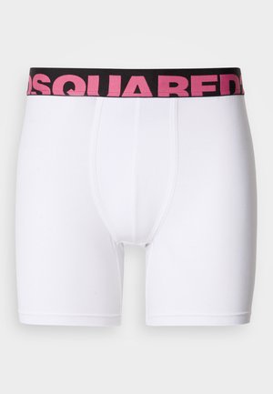 Valged puuvillased bokserpüksid, millel on kehale sobiv lõige, mustast elastset vööst, millel on roosa "DSQUARED2" logo.