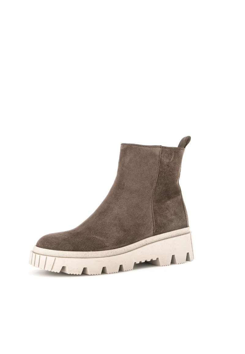 Bottine en daim marron avec une épaisse semelle blanche, présentant un motif texturé et une languette à l'arrière pour un enfilage facile.