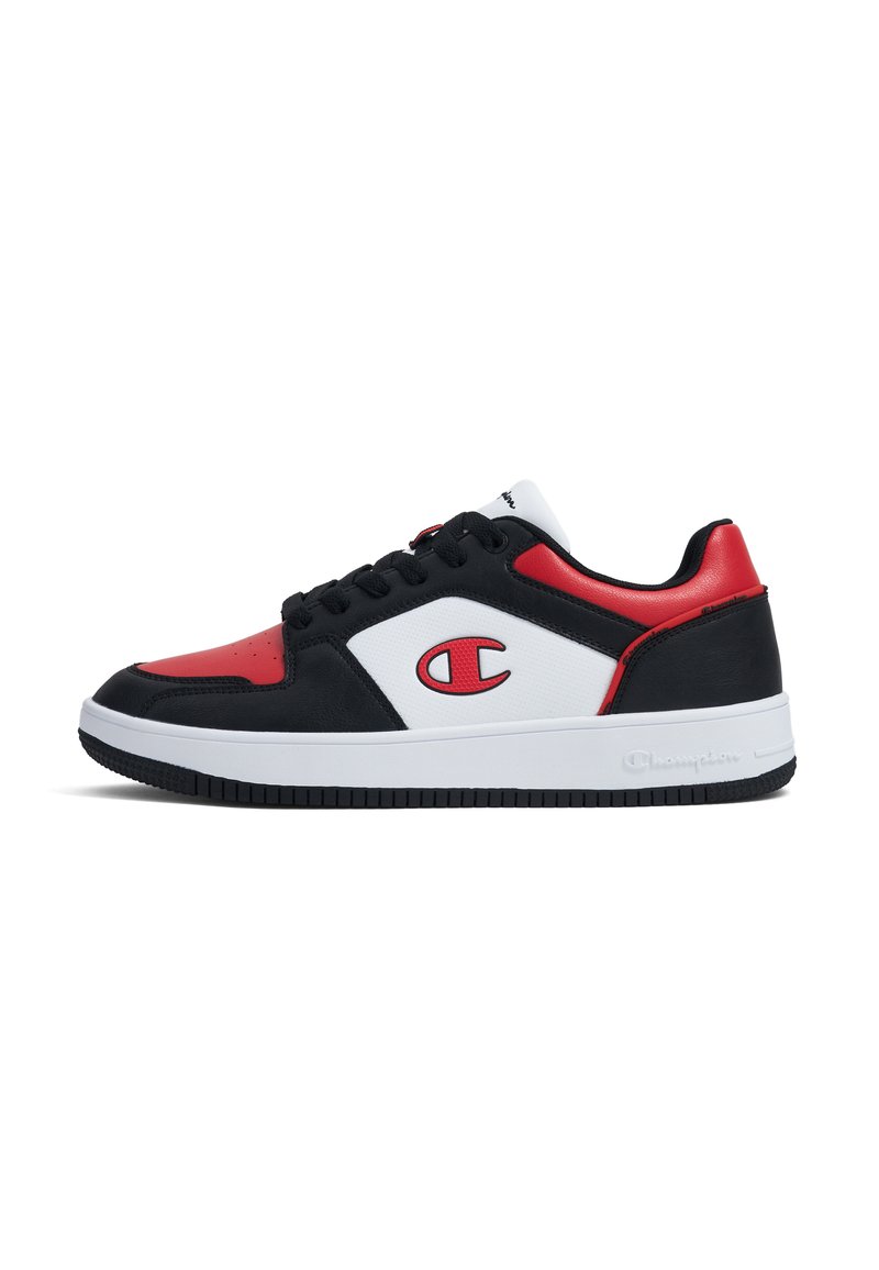 Baskets de sport noires, rouges et blanches avec une texture lisse, présentant une pointe arrondie, un laçage et un logo prominent sur le côté.