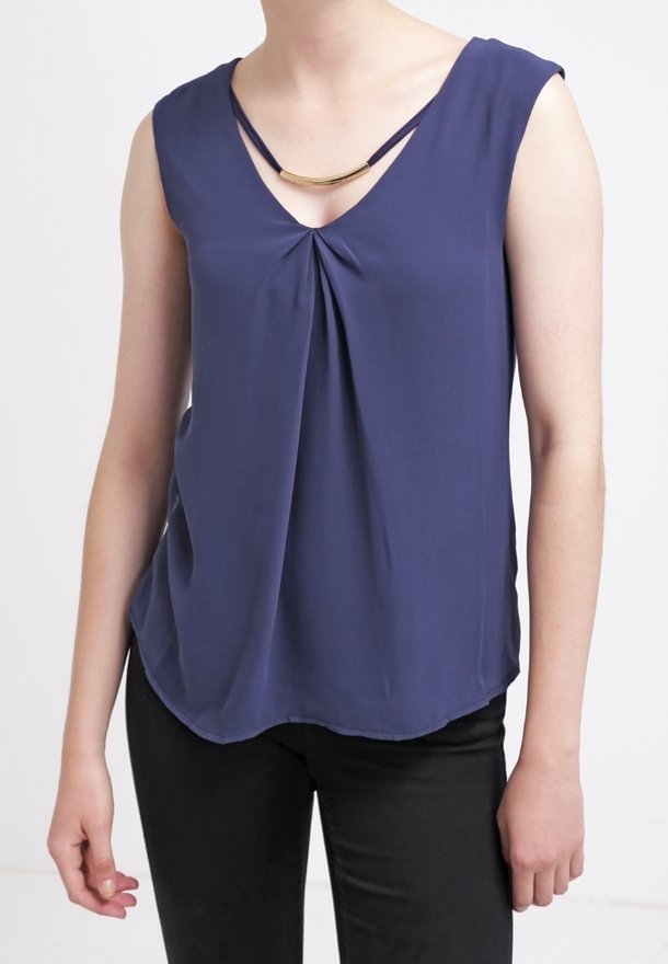 Laine tummansininen hihaton paita, jossa on V-pääntie ja laskostettu etuosa, hienovarainen kierto sekä kullanvärinen koru. Sileä kangas, rento istuvuus.