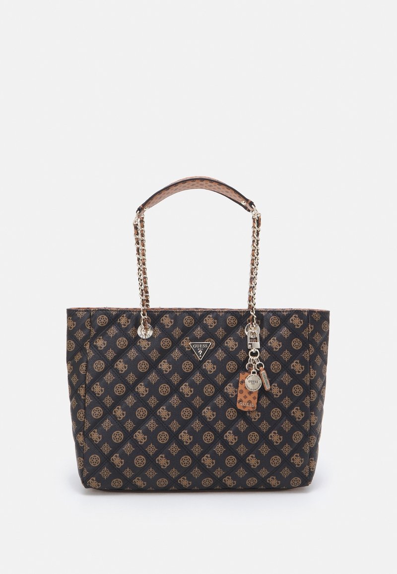 Sac cabas Guess à motifs noirs et marron avec poignées en chaîne et cuir, arborant le logo de la marque et des breloques de porte-clés à l'avant.