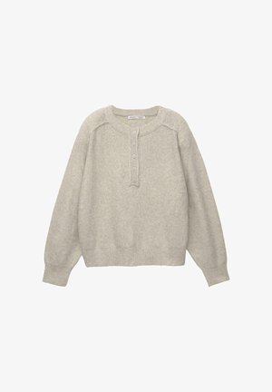 Svijetlo siva, mekano teksturirana majica s okruglim izrezom, dugim, blago napuhanim rukavima i plaketom s gumbima. Ribanog rebra na manžetama i po rubu.