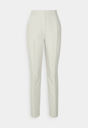 Jasno kremowe spodnie o dopasowanym kroju z prostymi nogawkami, z dwoma plisami z przodu oraz szlufkami na pasek, wykonane z gładkiego, teksturowanego materiału.