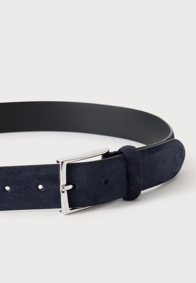 Ceinture en daim bleu foncé avec boucle rectangulaire argentée et passant en daim assorti sur fond clair.