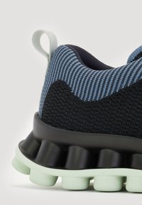 Sneaker mit einem strukturierten schwarzen Mesh-Obermaterial, blauen gestreiften Akzenten und einer schwarzen Zwischensohle mit mintgrünen Dämpfungselementen.