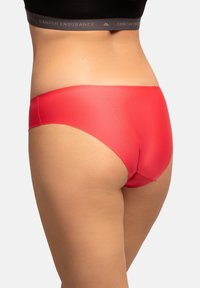 Intimo rosso senza cuciture con una finitura liscia e opaca. Caratterizzato da un design a vita alta e da cuciture minime per il massimo comfort. Senza etichette o dettagli visibili.