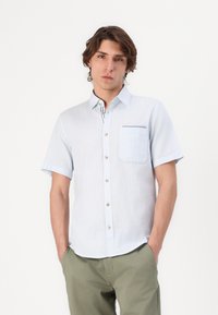 Light blue short-sleeve button-up shirt made of textured fabric, featuring a chest pocket with a contrasting trim and small buttons.