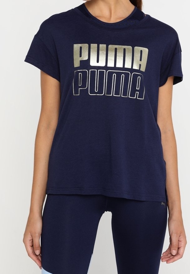 Tmavě modré bavlněné tričko s krátkými rukávy, s velkým kovovým stříbrným logem "PUMA" tištěným na hrudi. Kulatý výstřih.