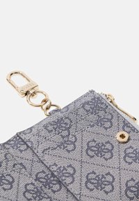 Portafoglio grigio testurizzato con motivo floreale, hardware dorato, chiusura con zip e clip removibile. Forma rettangolare compatta.