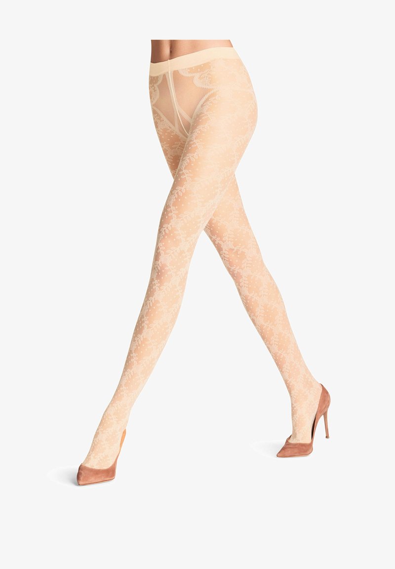 Collant nudi con motivi e dettagli in pizzo floreale, caratterizzati da una texture morbida e una fascia in vita ampia, abbinati a tacchi alti rosa chiaro.