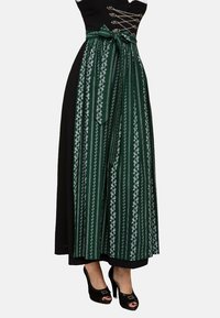 Langes Kleid mit einem schwarzen Oberteil und grünem Rock, der weiße Blumenmuster und vertikale Streifen aufweist; beinhaltet einen passenden Gürtel und Peeptoes.