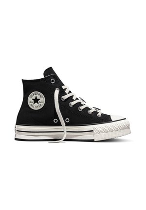 Schwarzer hoher Converse All Star Sneaker mit weißen Schnürsenkeln, Gummisohle und dem charakteristischen runden Logo-Patch am Knöchel. Ein Schnürsenkel ist lose.
