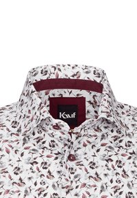 Camicia bianca con un motivo floreale in tonalità di rosa e grigio. Presenta un colletto di accento bordeaux e chiusura con bottoni. Etichetta del marchio visibile.