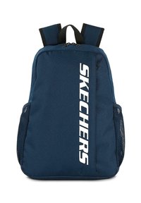 MOCHILA azul marino con un acabado de tela suave, que presenta un gran logo blanco de "SKECHERS" en la parte frontal, bolsillos laterales de malla y correas ajustables.