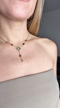 Χρυσή αλυσίδα με λουλουδάτα και αστέρι σχήματα, διαθέτοντας ένα κεντρικό κρεμαστό pendant με ένα διαφανές πολύτιμο λίθο. Σχεδίαση αλυσίδας ομαλή.