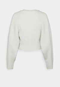 Avklippt, ljusgrön tröja med ribbad textur, långa raglanärmar och rund halsringning. Enkelt design utan ytterligare accentuerade detaljer.