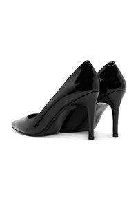 Zwarte lakleren high heels met een spitse neus en een slanke stilettohak, voorzien van een uitsparing bij de voetboog voor een extra ontwerpdetaillering.
