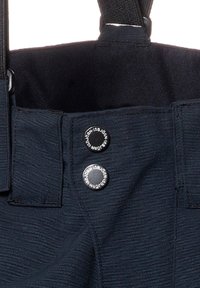 Svarta tygbyxor med texturerad yta, justerbara remmar och två märkta svarta knappar i midjan.