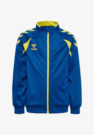 Blaues Sportjacke mit gelbem Reißverschluss, gelben Chevronstreifen auf den Schultern, gelben Seitenpaneelen und einem gelben Hummel-Logo auf der Brust.