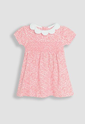 Rozā ziedu kleita ar īsām piedurknēm, krokojumu krūšu daļā un baltu viļņotu apkakli. Audumam ir maiga tekstūra un rotaļīgs raksts.