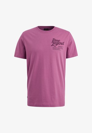 T-shirt à manches courtes et col ras du cou en coton violet vif. Présente un texte graphique noir sur le côté gauche, avec une texture lisse et une coupe décontractée.