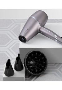 Στεγνωτήρας μαλλιών σε μεταλλικό γκρι με υφή, που διαθέτει μαύρη μύτη και δύο επιπλέον μαύρες κεφαλές στυλ.
