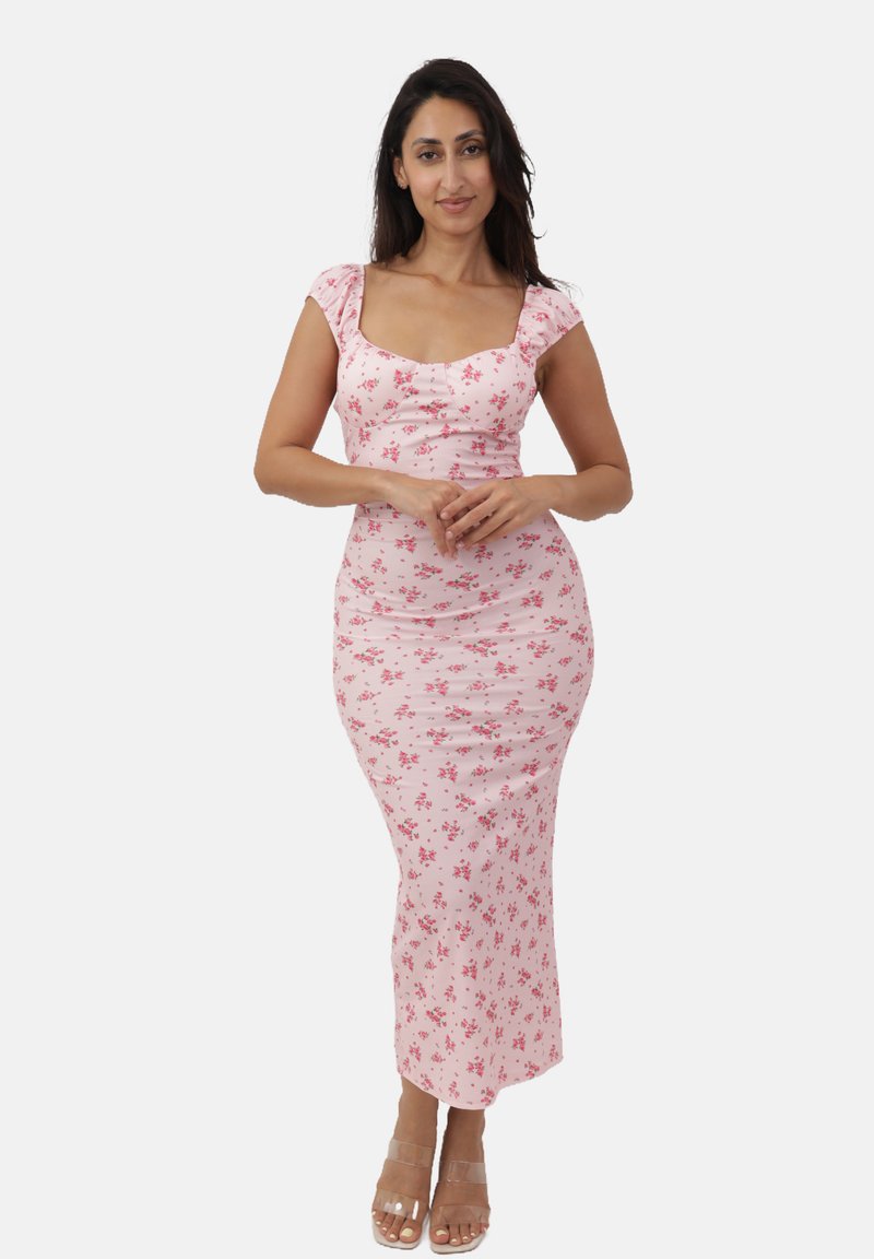 Różowa kwiatowa sukienka midi z krótkimi bufkami, dopasowanym krojem i miękkiej tkaniny. Przezroczyste sandały na paskach dopełniają całość.