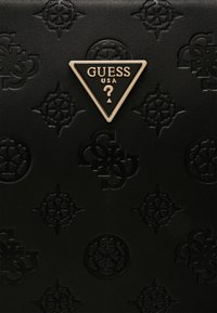 Musta nahkalompakko, jossa on korokepainetut kuviot ja kultainen kolmionmuotoinen Guess-logo. Pinnassa on runsaita kuvioita ja yksityiskohtia.