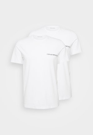 Bílé bavlněné trička s krátkým rukávem a kulatým výstřihem, označená "EMPORIO ARMANI" černým písmem na levé části hrudi. Balení po dvou.