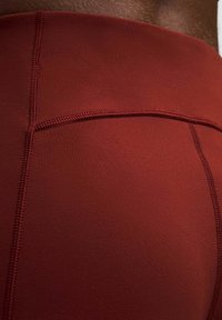 Piros sport leggings sima, rugalmas anyagból, látható varrási részletekkel. Magas derékrésszel rendelkezik a fokozott támogatás érdekében.