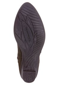 Svart gummisula med texturerat greppmönster, med ett lövdesign och präglat varumärke. Rundad, hållbar form för stabilitet.