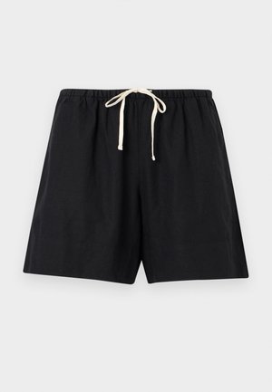 Μαύρο άνετο σορτς με ελαστική μέση και λευκό κορδόνι, τοποθετημένο επίπεδα σε ανοιχτό γκρι φόντο.