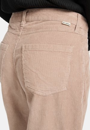 Lichtroze corduroy broek met verticale ribbels, twee achterzakken en een klein merkje op de tailleband.