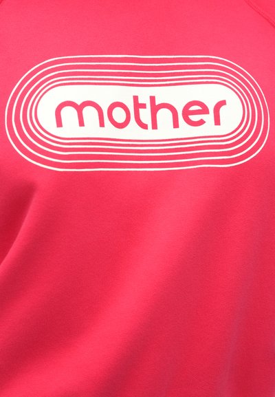 Rožinis džemperis su užrašu „mother“ baltais rašmenimis, apsuptas apskritimų linijų. Minkštos tekstūros audinys, laisvo kirpimo dizainas.