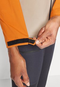 Peak Performance TRAIL JACKET - Veste Hardshell - pure gold/avid beige/gold flame
