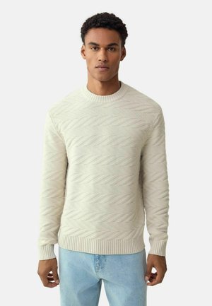 Light beige pullover sweater with a textured zigzag pattern, ribbed crew neckline, and cuffs. Made from a soft knit material.