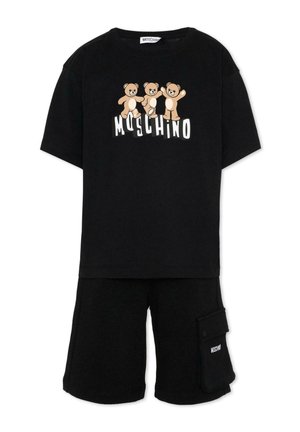 Czarny krótki rękaw z trzema misiami nad białym napisem "MOSCHINO", w połączeniu z czarnymi szortami z boczną kieszenią i logo.