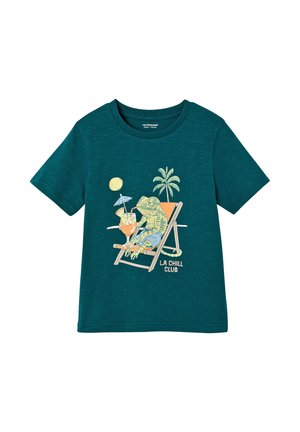 Teal short-sleeve t-shirt with a lizard in shorts lounging on a deck chair, holding a tropical drink under the sun and palm tree, "LA CHILL CLUB" text.