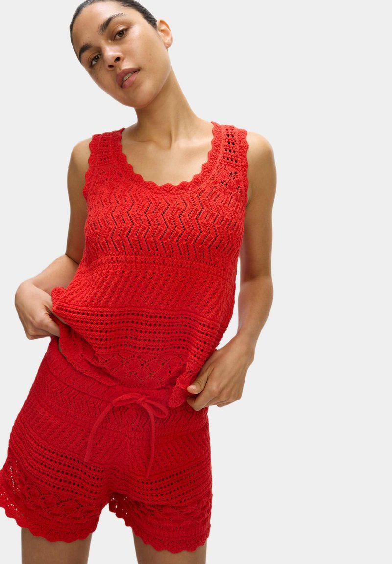 Rotes gehäkeltes Top und Shorts-Set, mit einem gewellten Ausschnitt, Zickzackmuster und Kordelzugbund. Leichte, strukturierte Strickware.